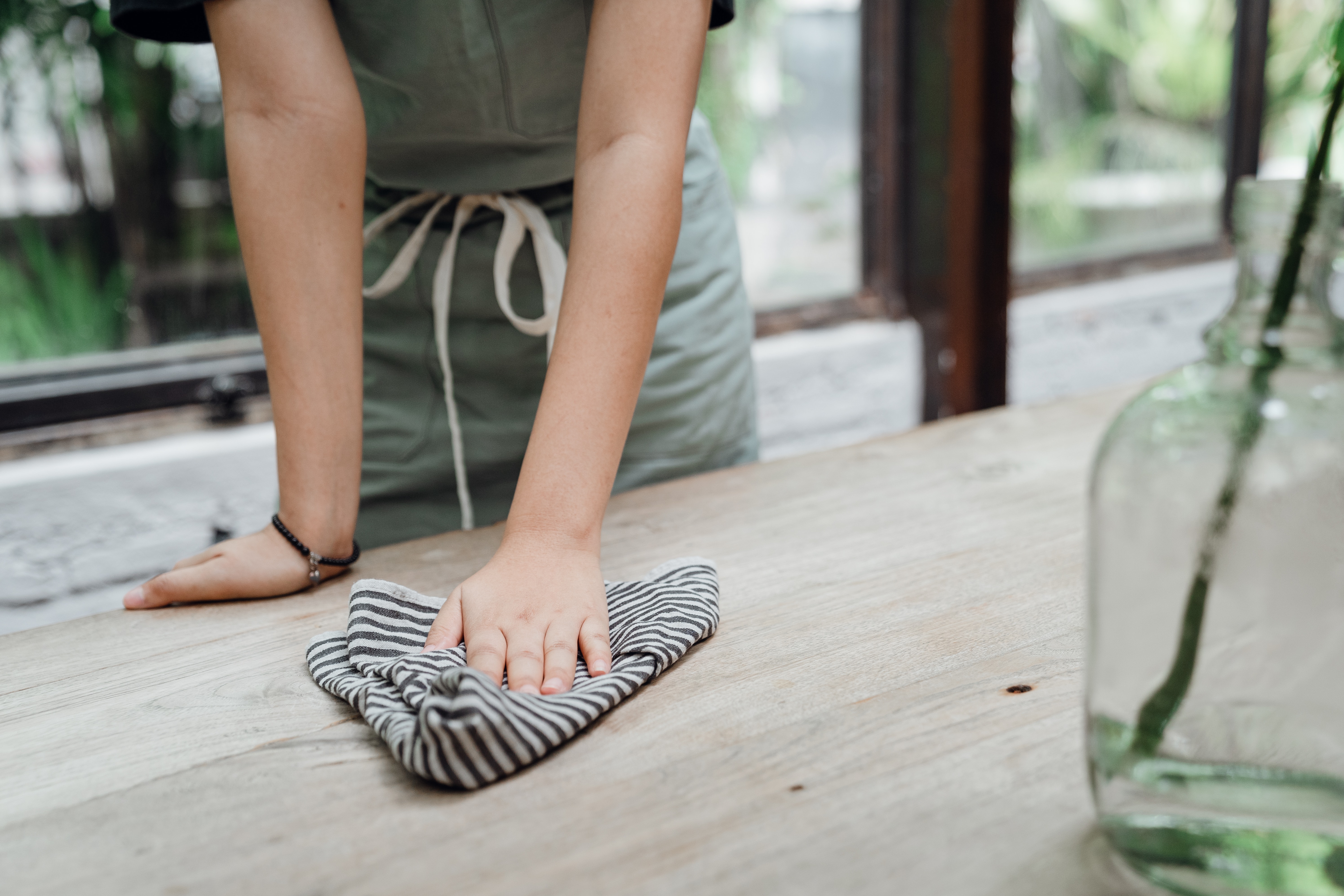 crop-waitress-wiping-table-with-piece-of-cloth-4350222